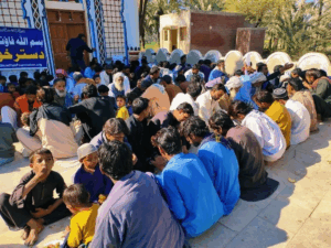People gathered outside a building, sitting together.