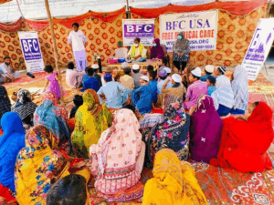 Community gathering under a tent with banners.